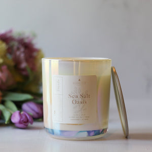 Candle labeled 'Sea Salt Oasis' with a blurred floral background