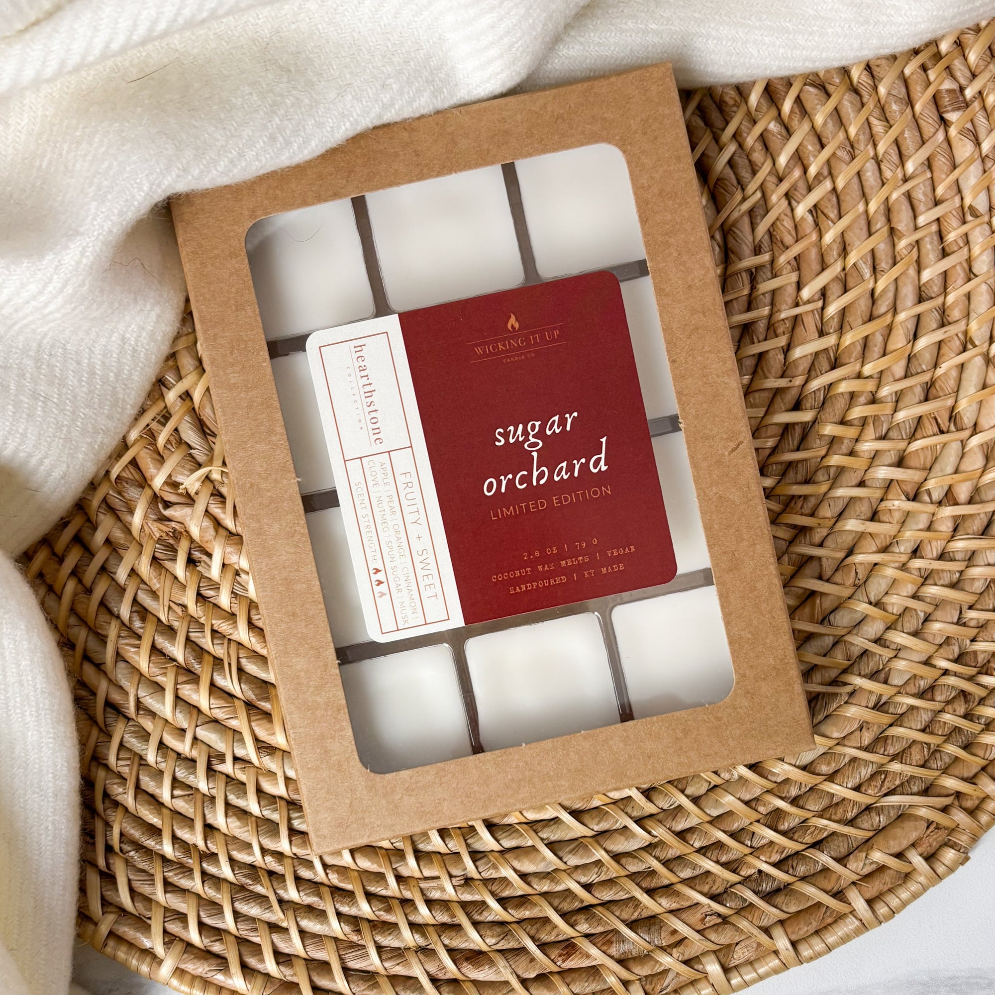 Packaged wax melts with 'sugar orchard' label on a woven surface.